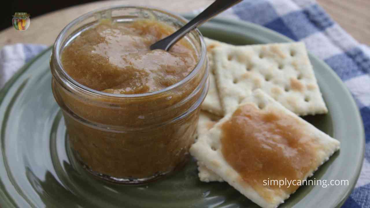 Opening jar of homemade apple butter to spread on crackers.]