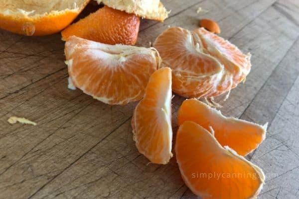 Bright orange segments sitting on a cutting board.