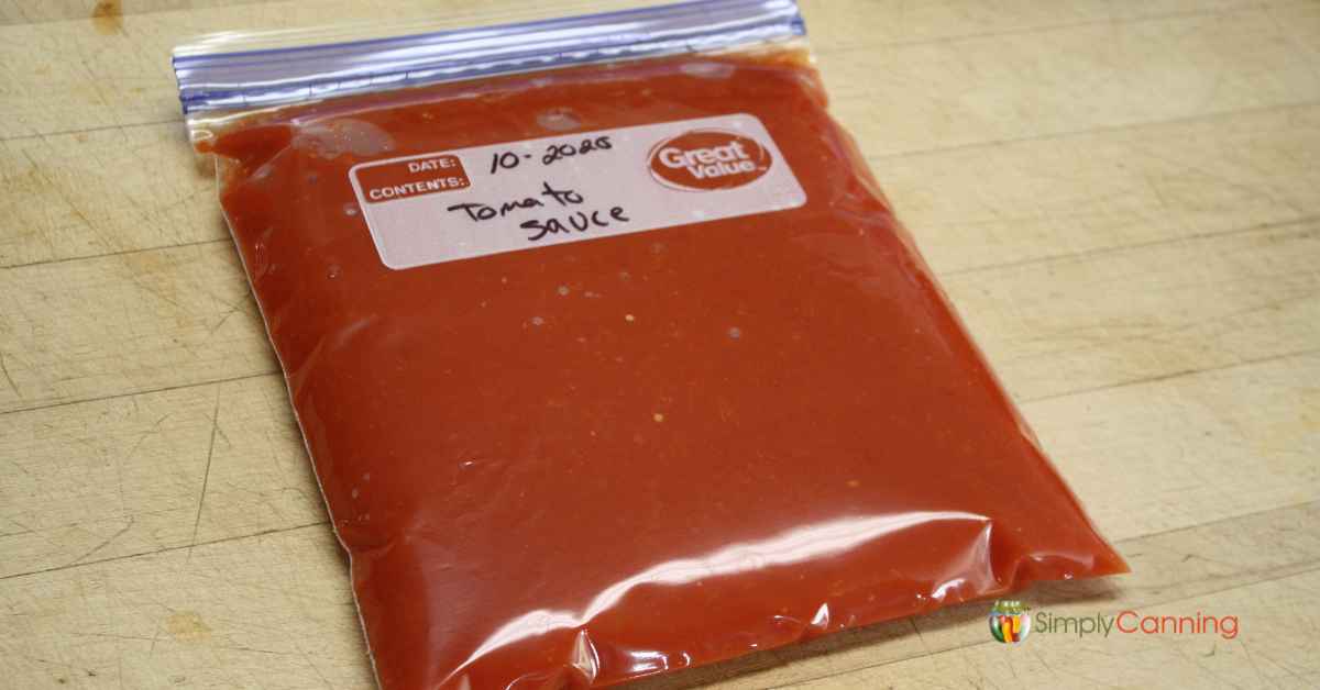 A filled freezer bag with tomato sauce in it.