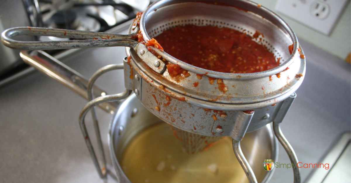 Straining off extra liquid from the tomatoes using my hand food mill.